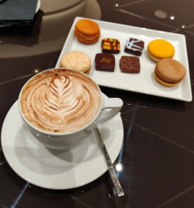 Cappuccino mit Macarons und Pralinen