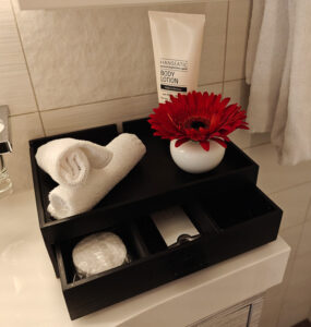 Box mit Bodylotion, Waschlappen, Nagelsets, Wattestäbchen, Wattepads