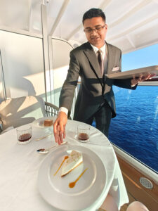 Butler Malay serviert die Desserts